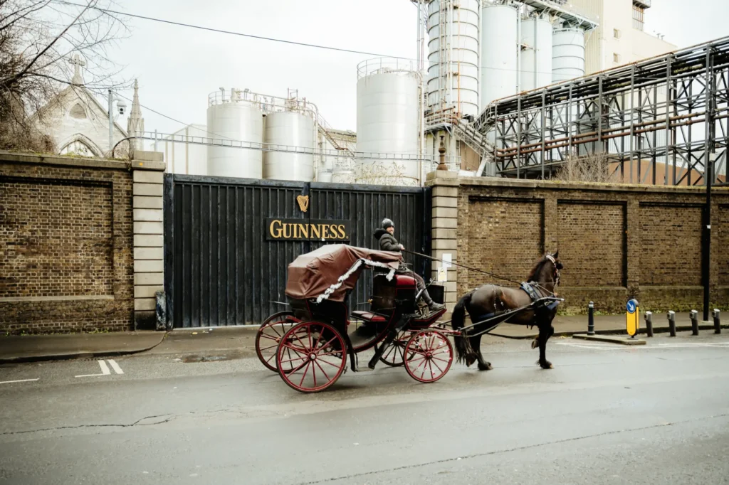 A horse and cart outside the big black guinness gates in the liberties in dublin