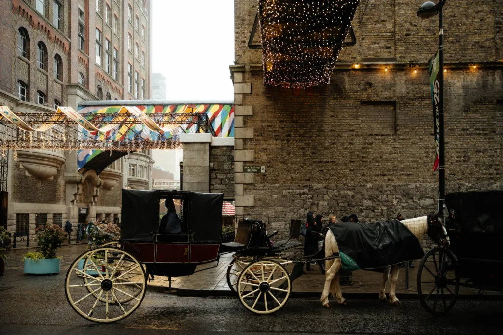 A horse and cart outside the big black guinness gates in the liberties in dublin