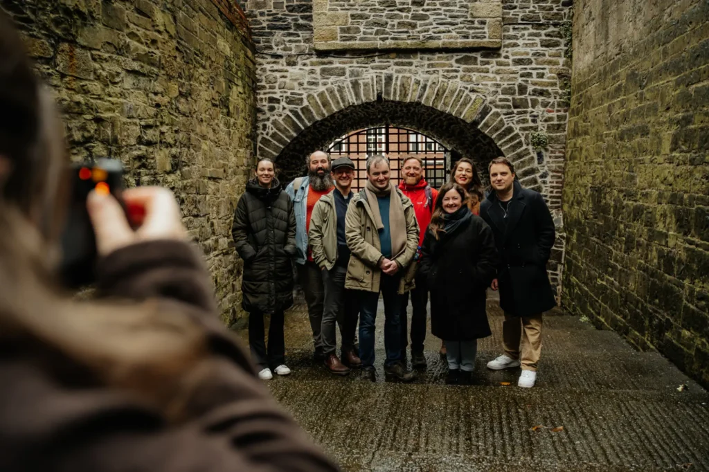 A group on a walking tour standing in front of the old city gates in dublin ireland