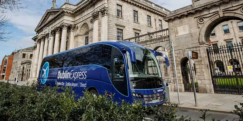 A Dublin Aircoach double-decker bus navigating busy streets on its route from Dublin Airport to the city centre