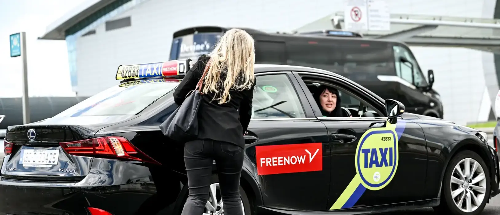 A visitor to dublin hailing a freenow taxi outside of dublin airport heading to the city centre