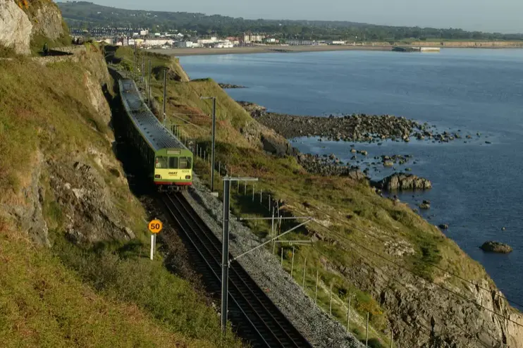 The DART train riding the coast of dublin leaving the city centre heading to howth